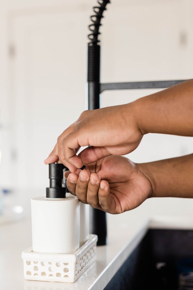 Hands Getting Soap for Handwashing in Kitchen Sink